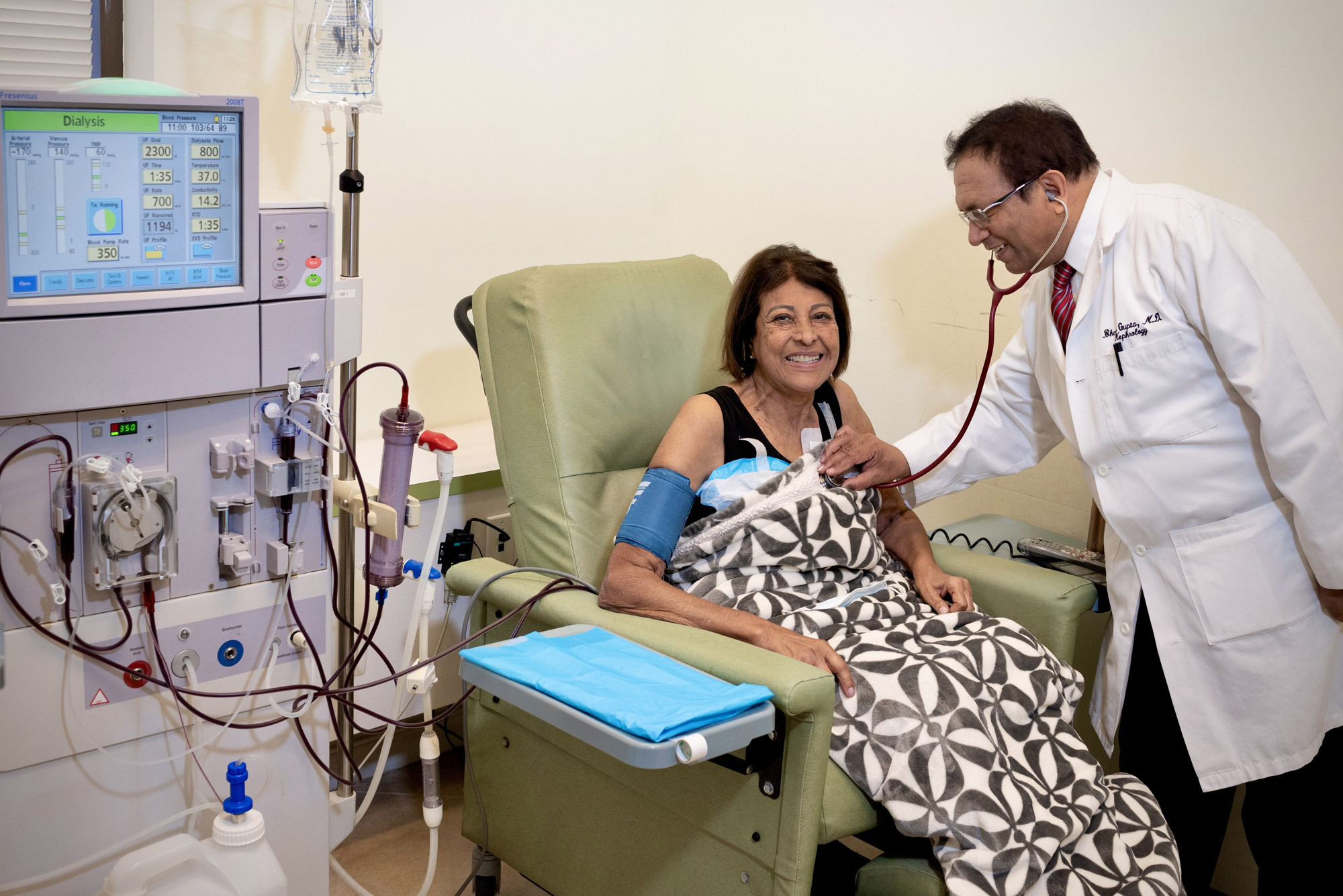 Dr. Gupta checking on a smiling patient during in-center hemodialysis