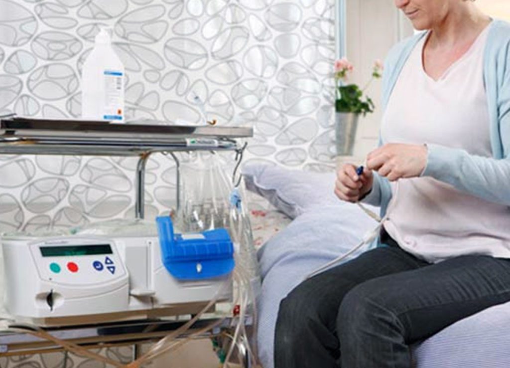 Patient setting up peritoneal dialysis equipment at home